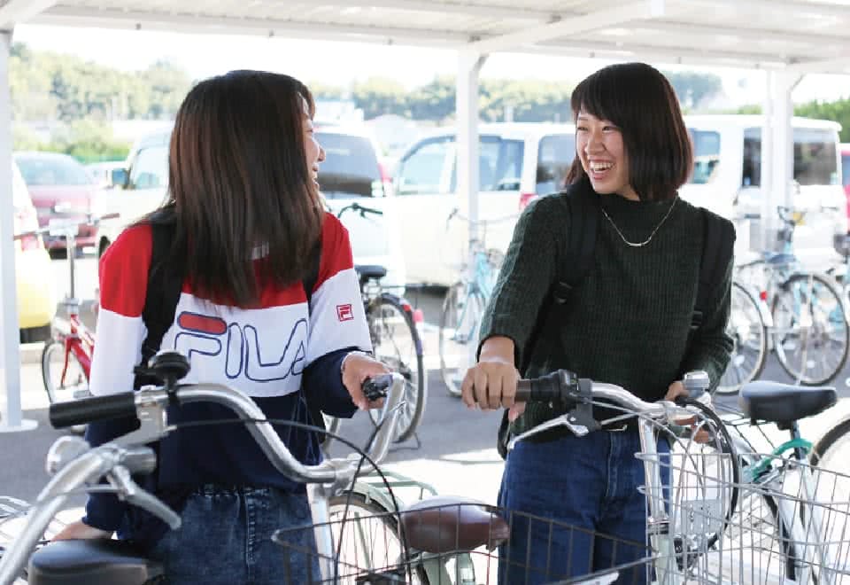 写真:駐輪場で友達を笑い合うAさん