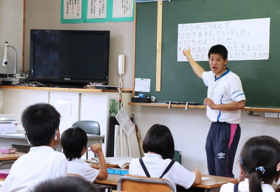 写真:小学校で教壇に立つ学生