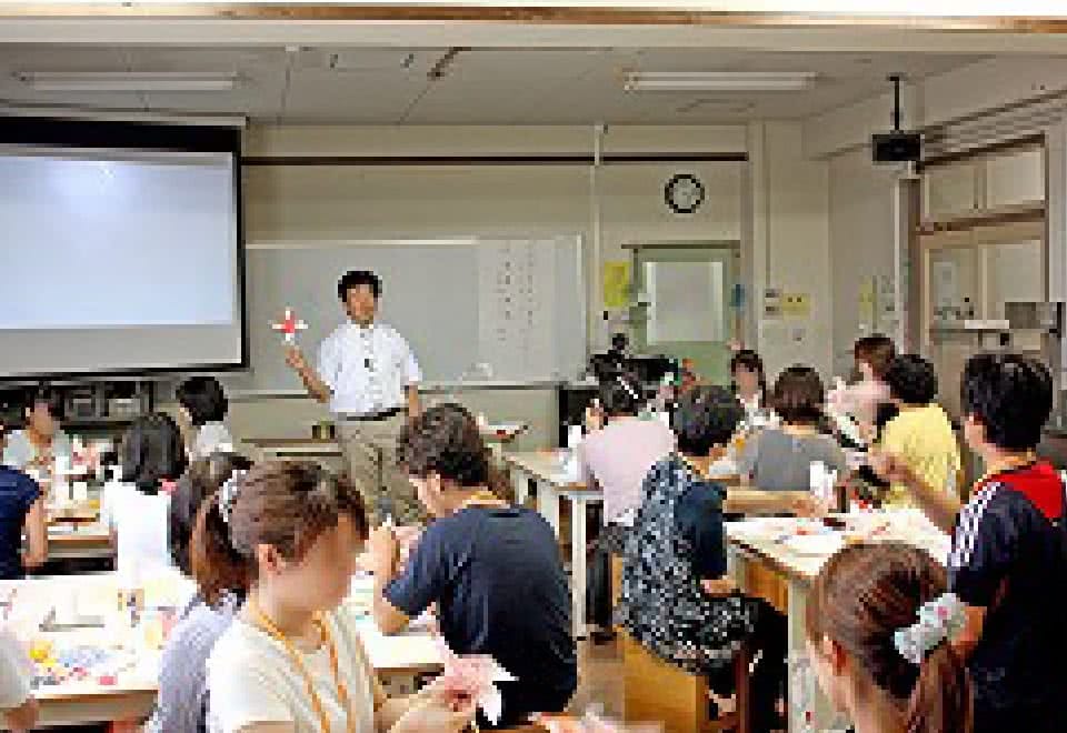 写真:研修会にて手作りおもちゃの作り方を指導する講師と受講する参加者