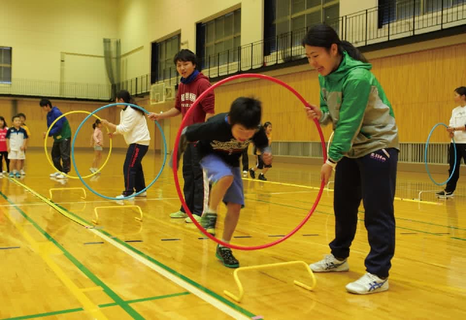 写真:美作クラブ。フラフープをくぐる男児