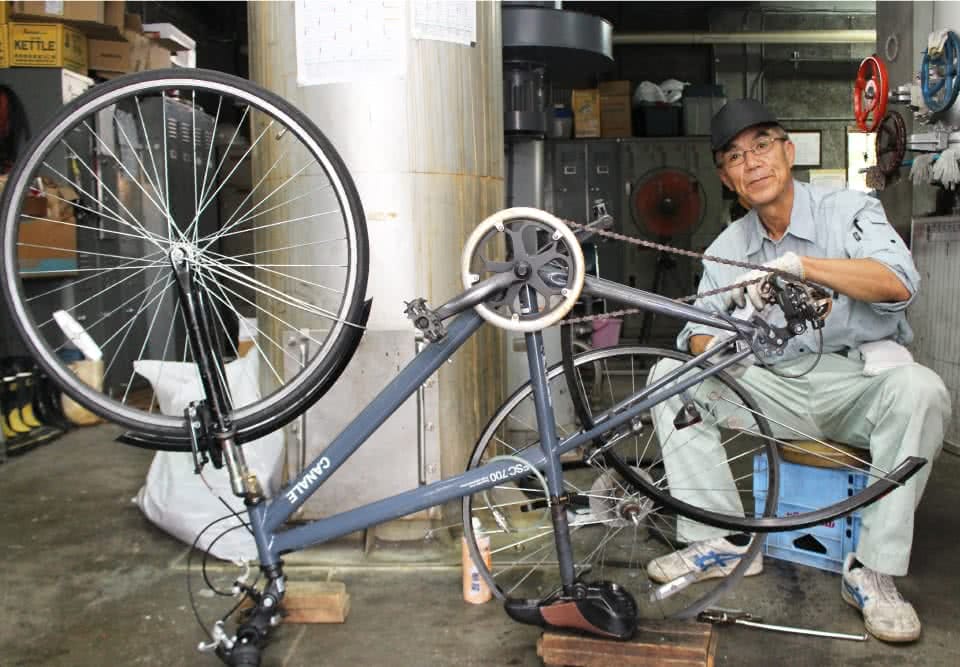 写真:自転車の修理をする男性の校務員さん