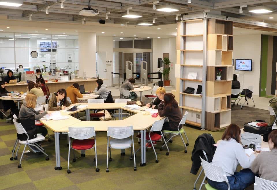 写真:ラーニング・コモンズの机で勉強をしている学生たち・机は六角形に組み合わされている。