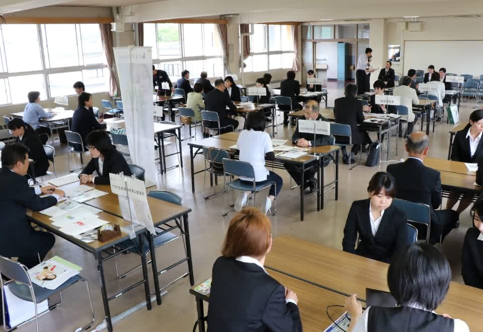 写真:合同企業説明会の各ブースで企業担当者から説明を受ける学生たち