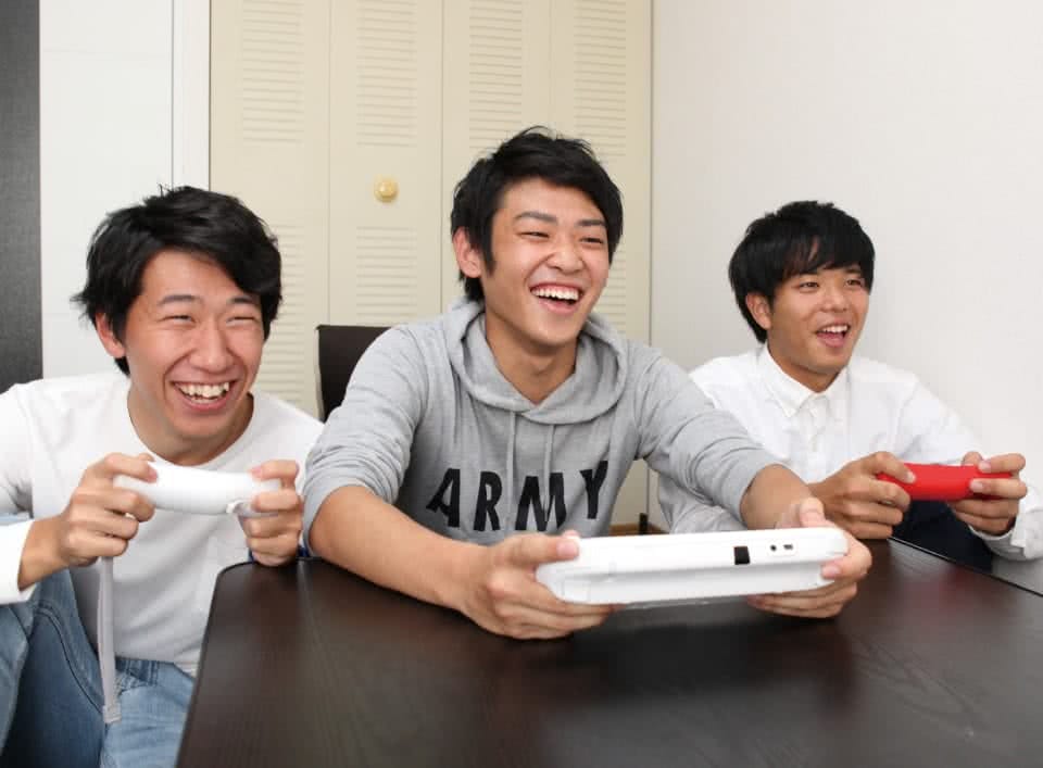 写真:アパートで友達二人とゲームを楽しむBさん