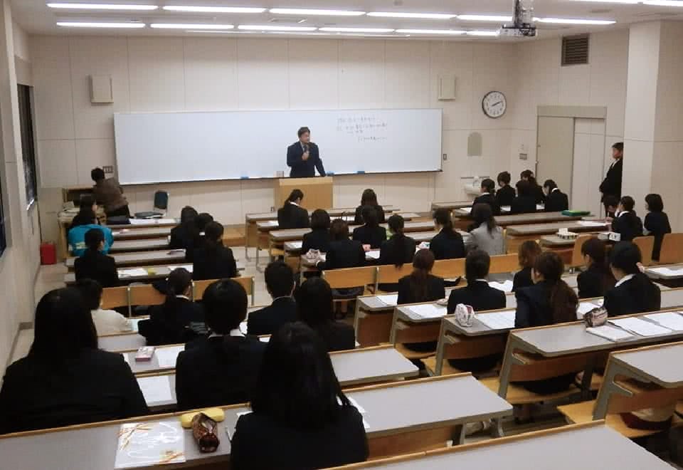 写真:ホワイトボードの前で生徒に向かって話している様子