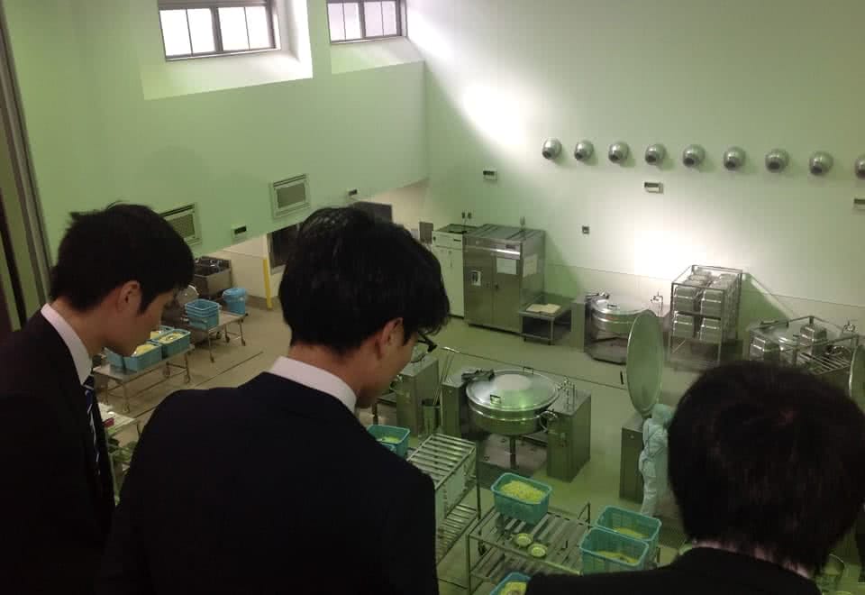 写真:給食センター見学。給食センターで給食が作られているのを見学している様子