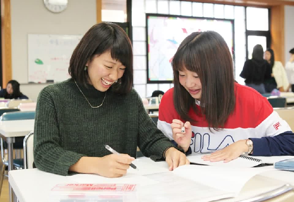 写真:友達とノートを開いているAさん