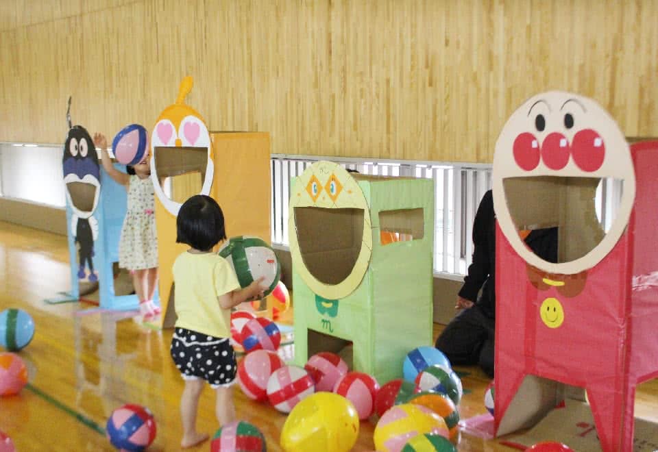 写真:アンパンマンのキャラクターの形をした手作りの遊具とそれで遊ぶ子ども
