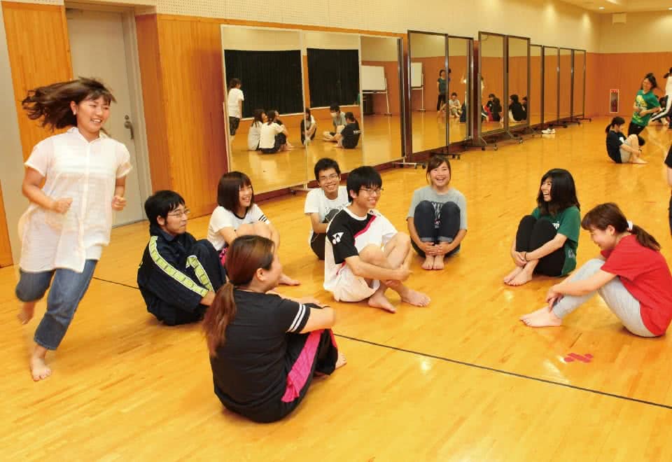 写真:円になりハンカチ落としゲームをする学生