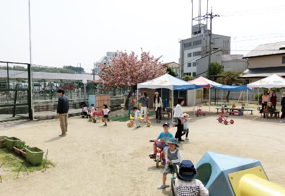 写真:附属幼稚園の園庭で遊ぶ子どもと保護者