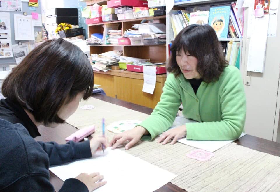 写真:女子学生の相談に乗っている担任の女性教員