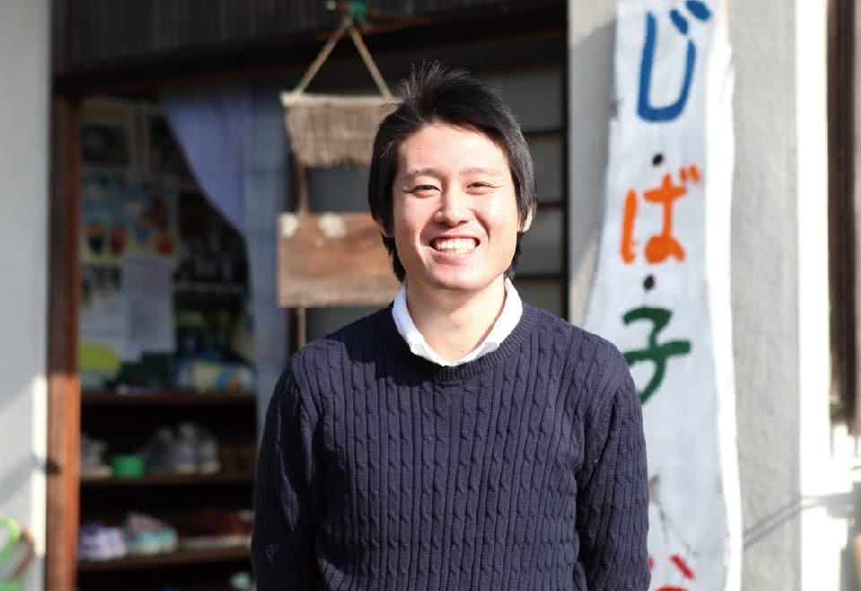 写真:男性が笑顔で立っている