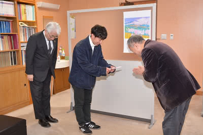 立正佼成会 津山教会長の東伸吉様から寄付金を受け取る学生