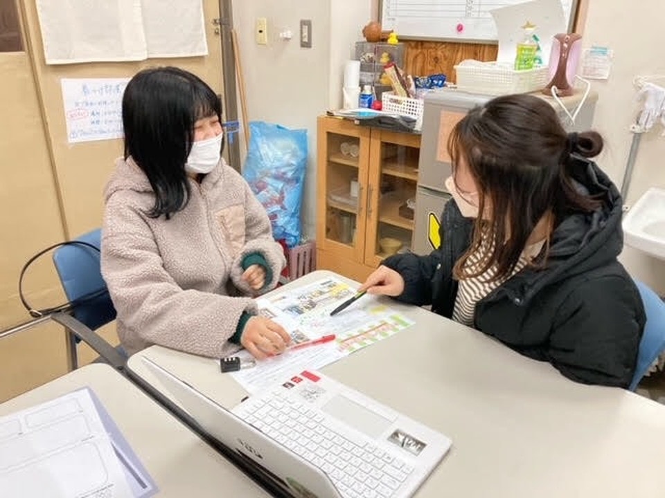 写真:和やかな雰囲気の中、資料やパソコンを使いながら親身に相談対応をする女性二人