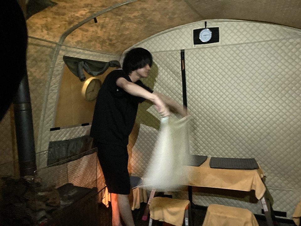 写真：サウナの室内でタオルを仰いでいる様子