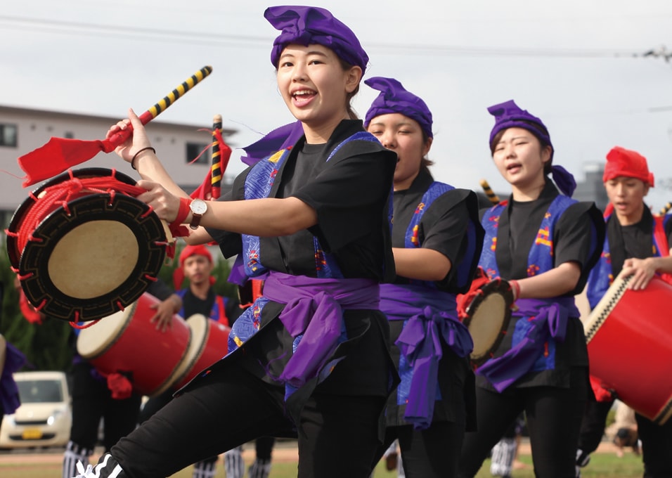写真：揃いの黒い衣装で和太鼓を手にエイサーを踊る県人会のメンバーたち