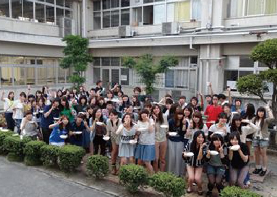 写真：校舎の前に集合して写真に収まる島根県人会のメンバーたち