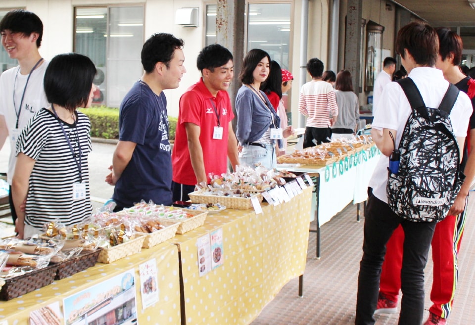 写真：パンやクッキーなどを販売する社会福祉学科の学生と、立ち寄った学生