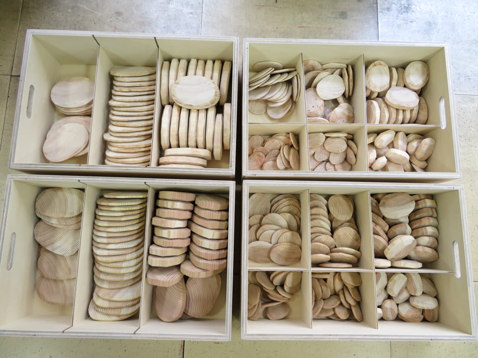 写真：仕切りのある箱に種類ごとに分けて入れられた木製石ころ積み木