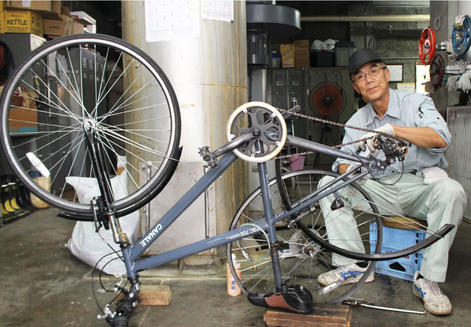 写真：自転車の修理をする男性の校務員さん