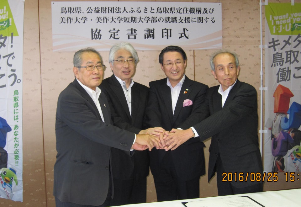 写真:鳥取県の締結式で握手をする平井伸治知事と池上勝治ふるさと鳥取県定住機構理事長、藤原修己美作学園理事長、鵜﨑実学長