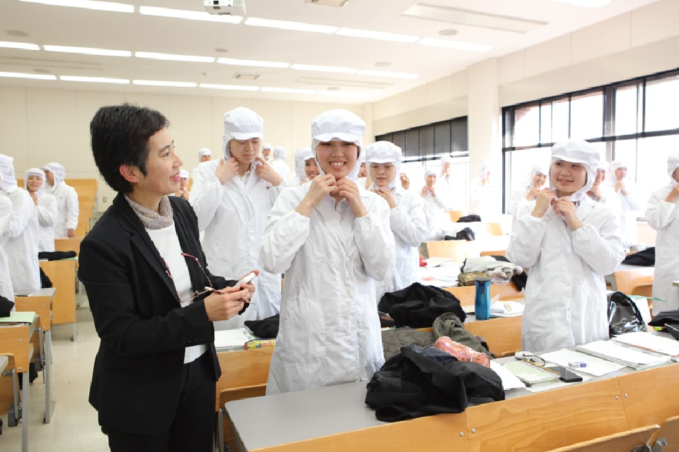 写真:調理服に手際よく着替えている