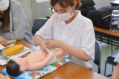 赤ちゃんの人形で学ぶ学生