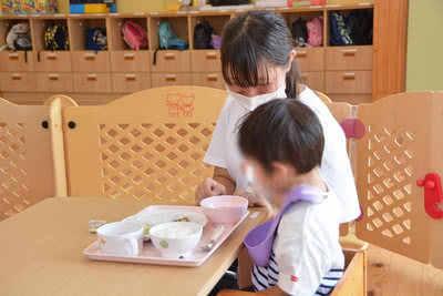 子どもの食事介助をする学生