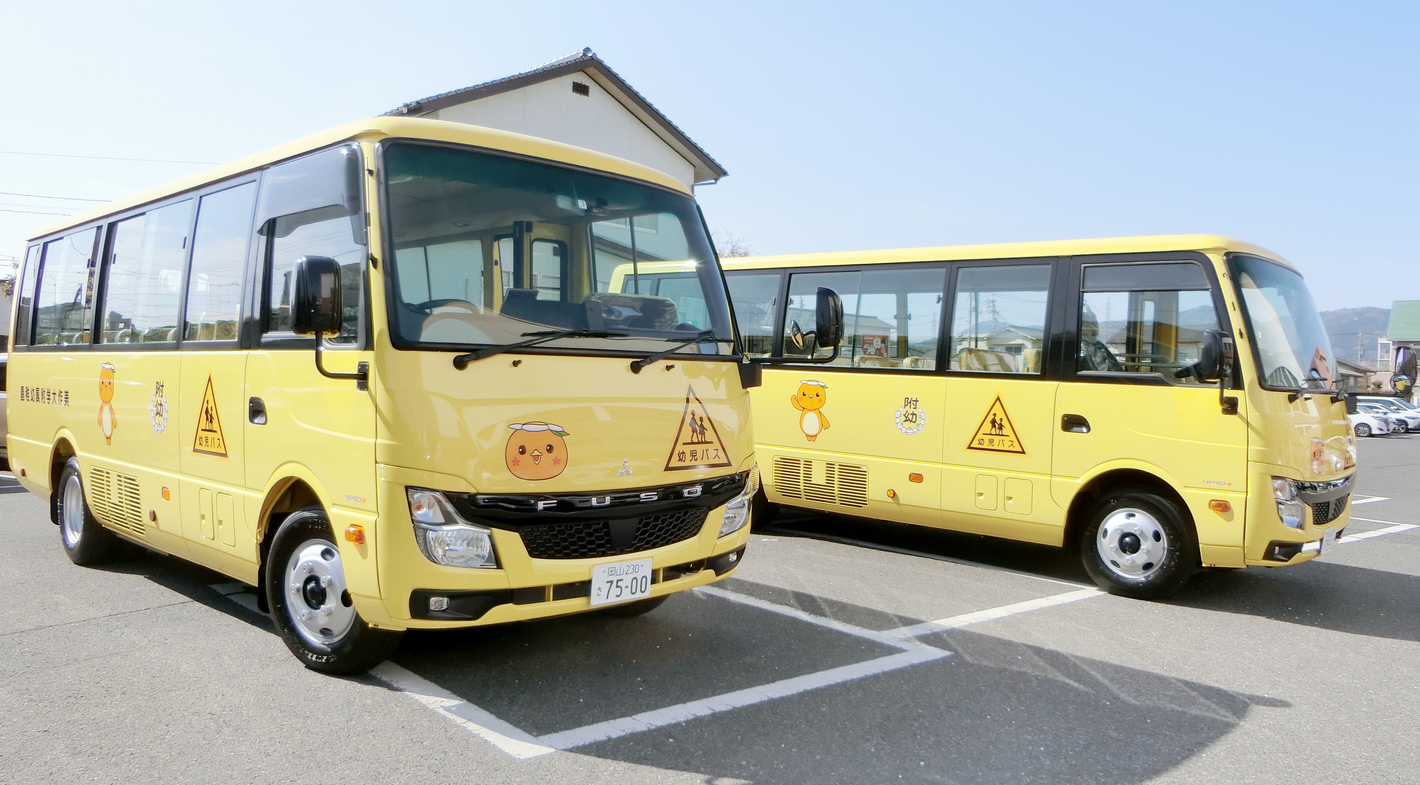 写真：幼稚園の前に停車している2台のスクールバス