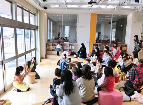 写真：絵本の読み聞かせに参加している子どもたちと保護者たち