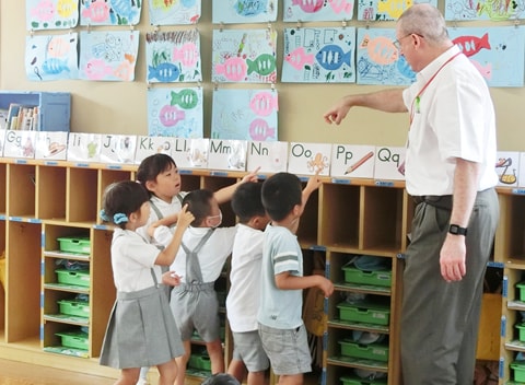 写真：アンドリュー先生による、アルファベットとイラストを使った英語の授業を受ける園児たち