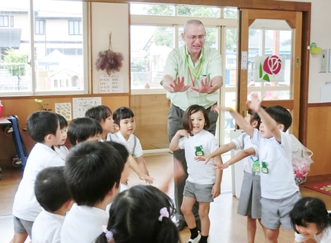 写真：アンドリュー先生に合わせて体を動かす英語の授業を受ける園児たち