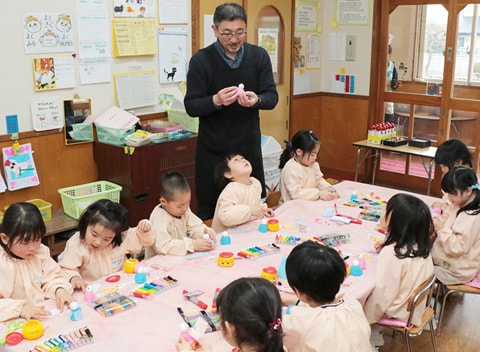 写真：中田先生の指導で絵を描いている園児たち
