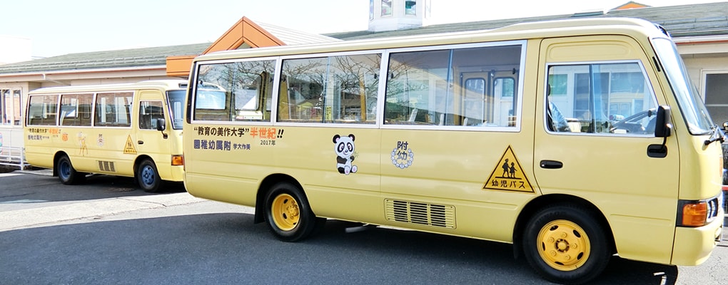 写真：幼稚園の前に停車している2台のスクールバス