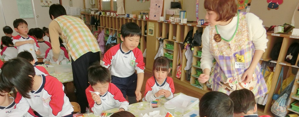 写真：保育室で実習中の学生と園児たち