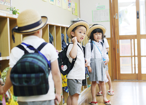 写真：教室のロッカーに通園用のリュックを取りに行く園児たち